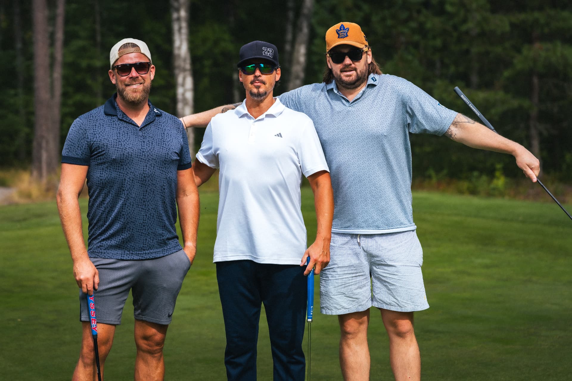 Tre spelare poserar på greenen