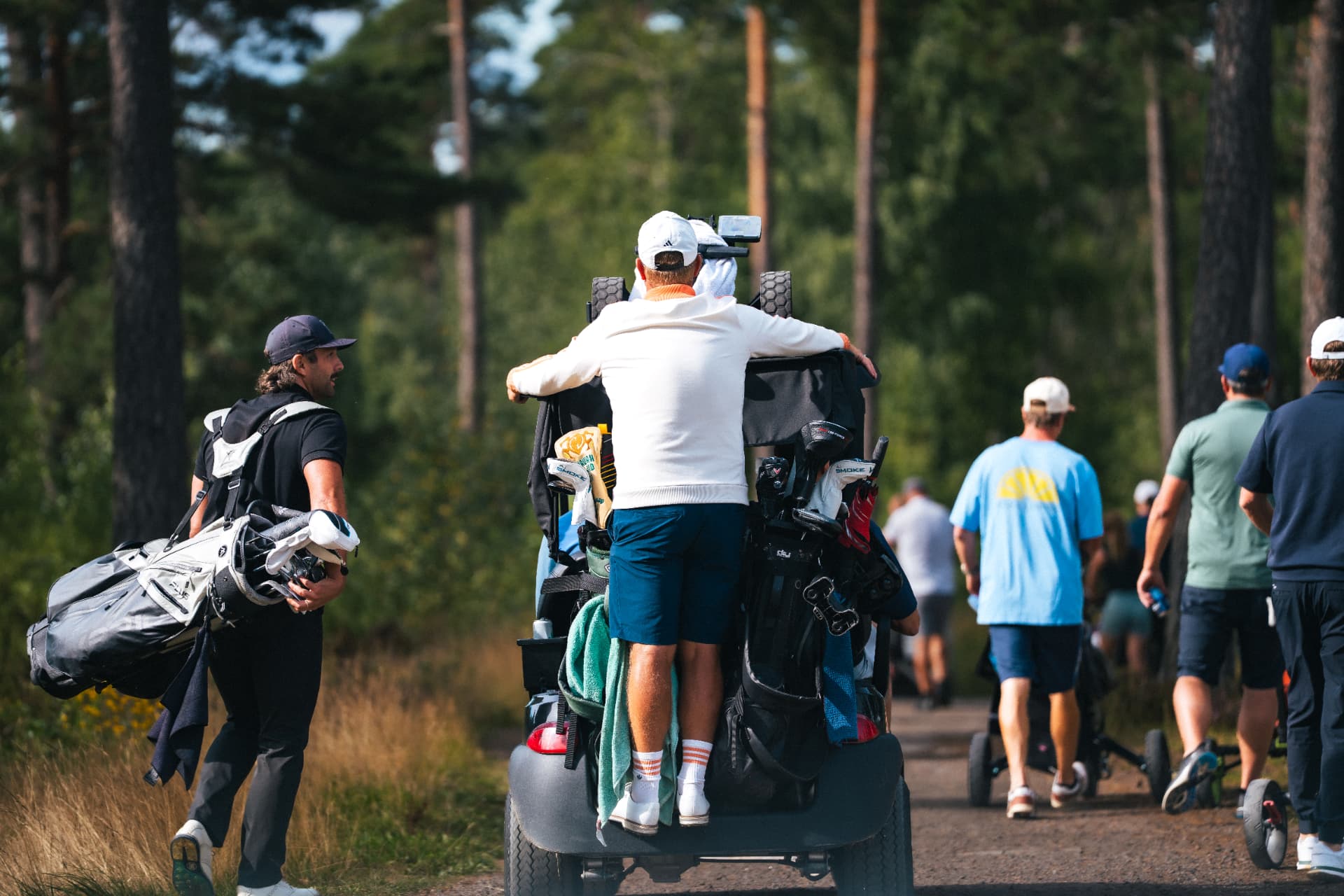 Deltagare på väg mot nästa tee genom tallskogen
