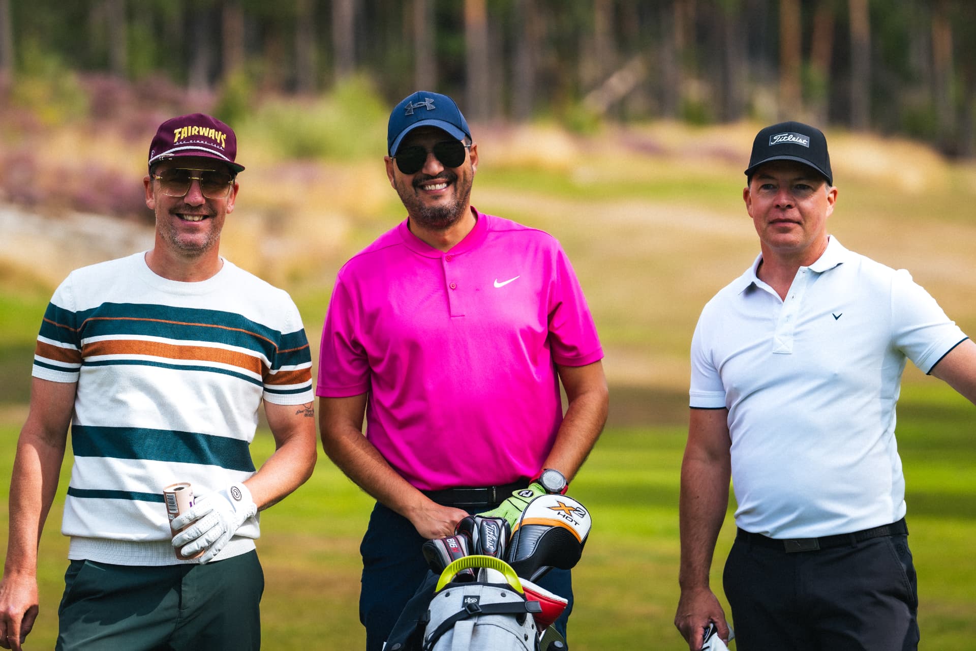 Tre spelare poserar på fairway