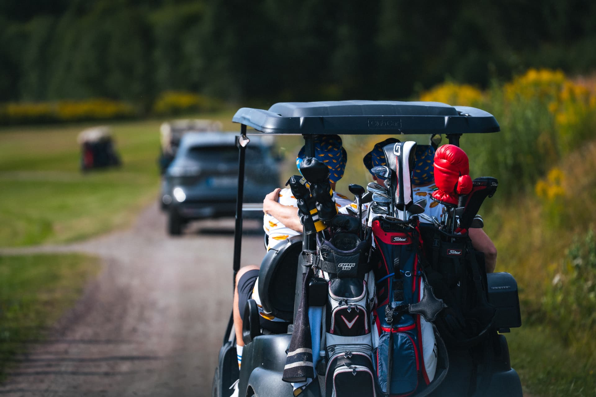 Golfbil på väg ut på banan med bagar