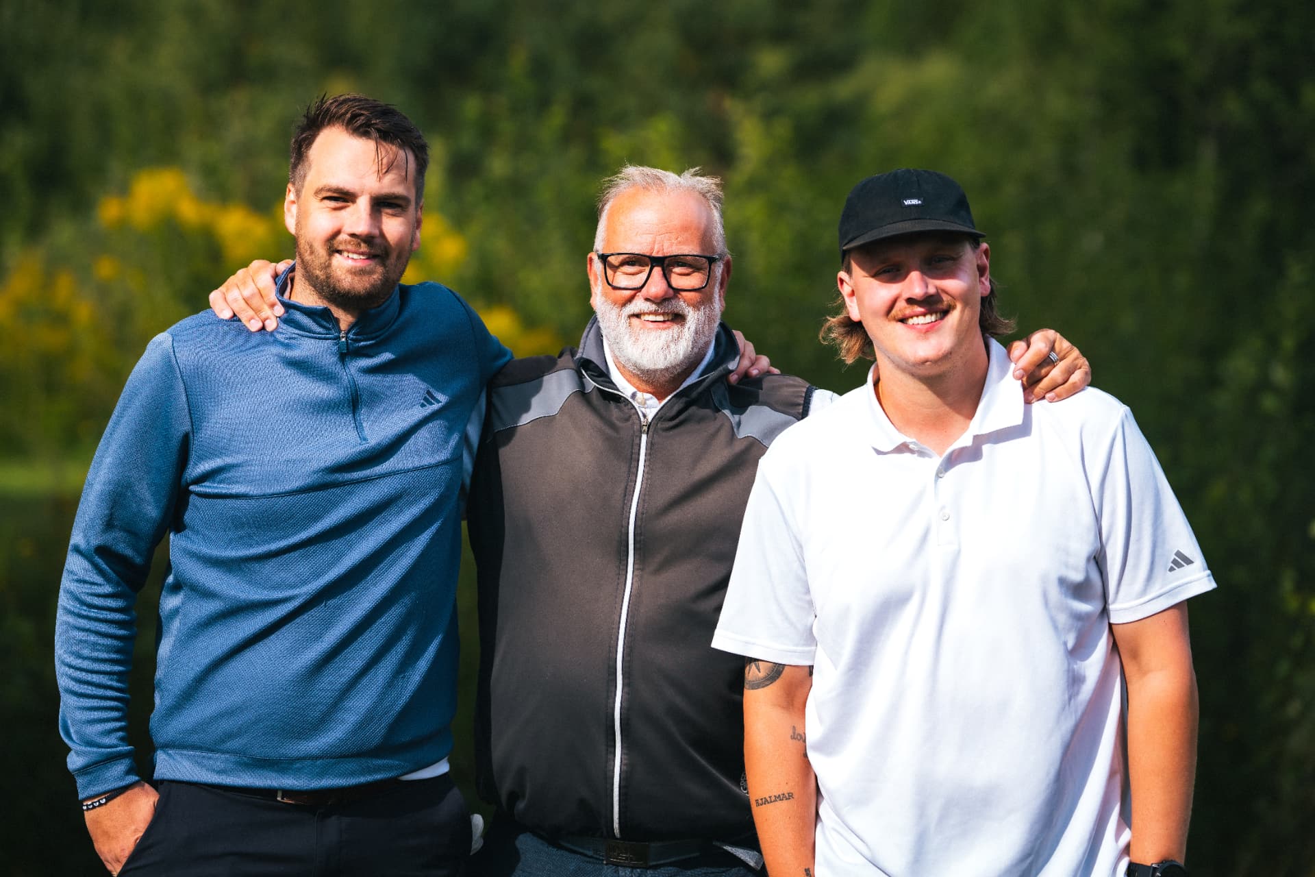 Tre spelare poserar tillsammans framför greenen