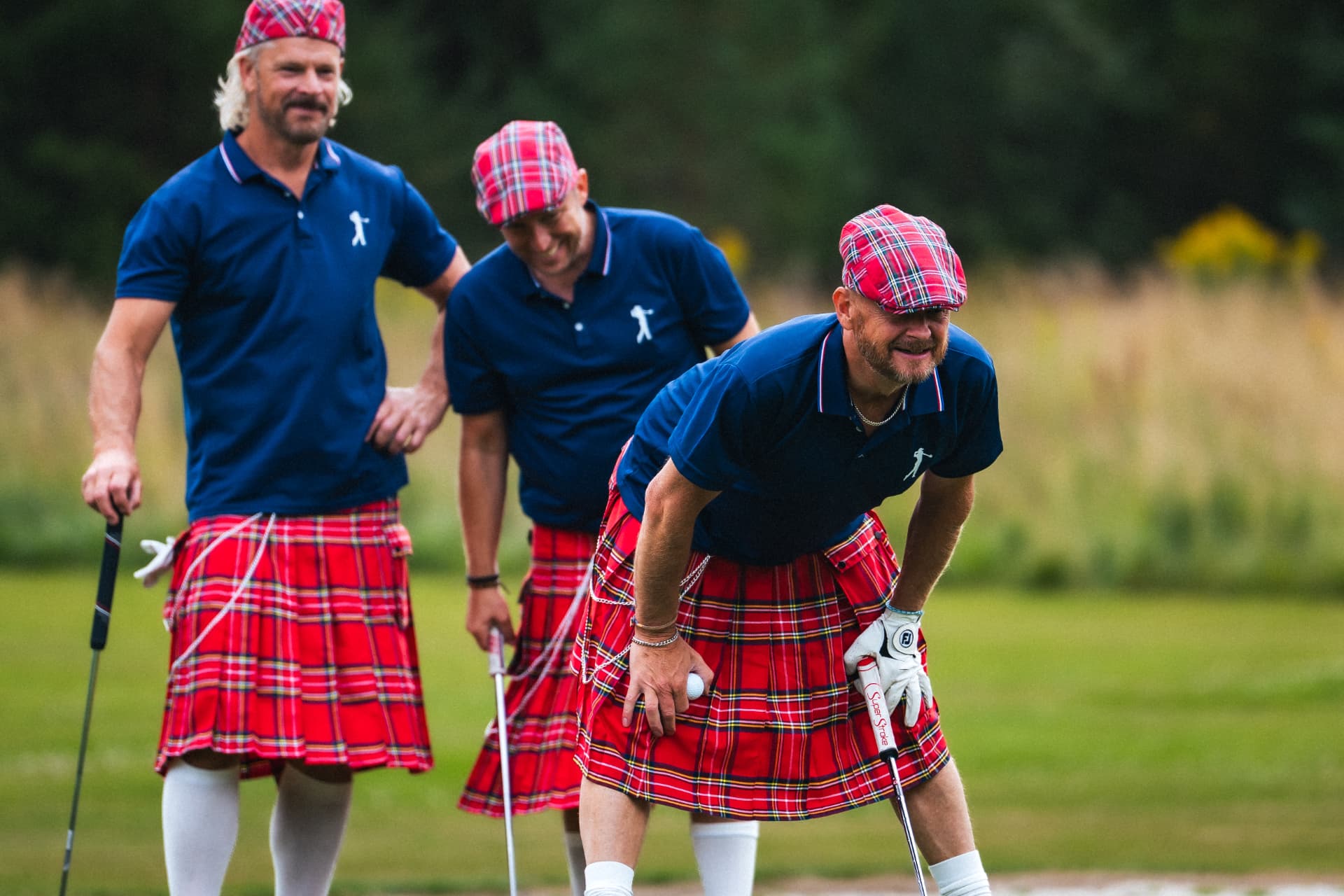 Kiltlaget skrattar på greenen
