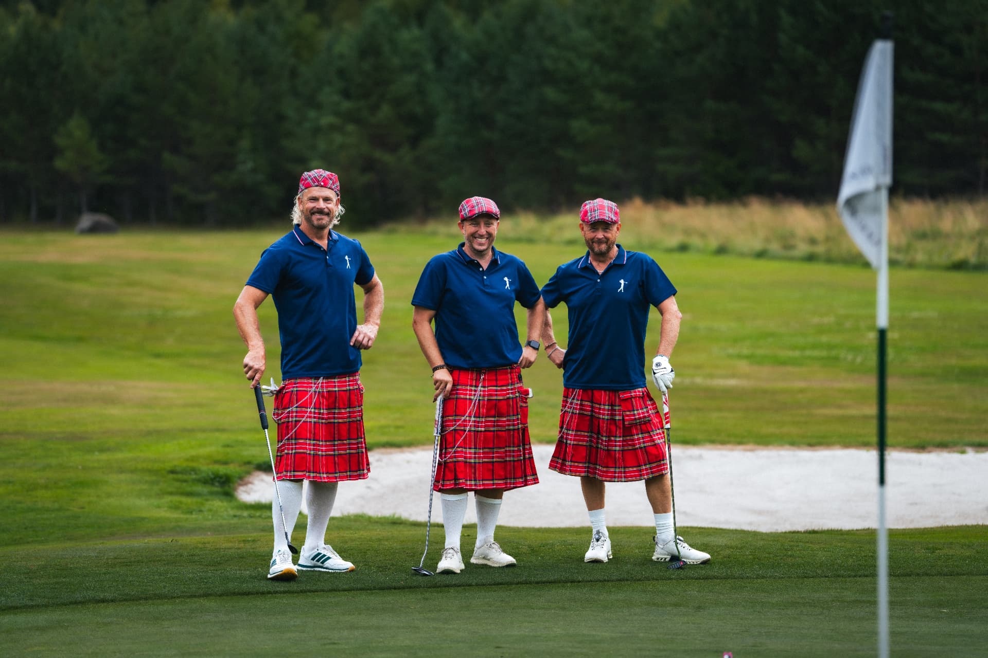 Tre spelare i kilt vid greenen