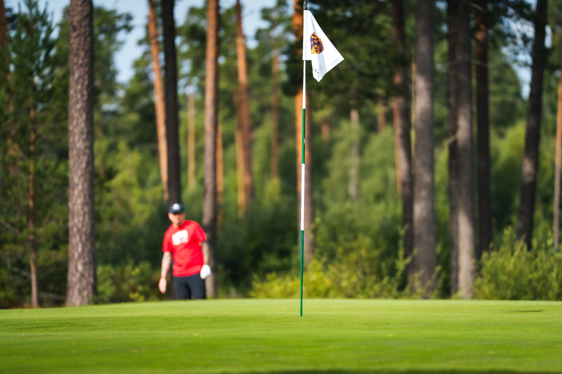 Flaggan på greenen med spelare i bakgrunden