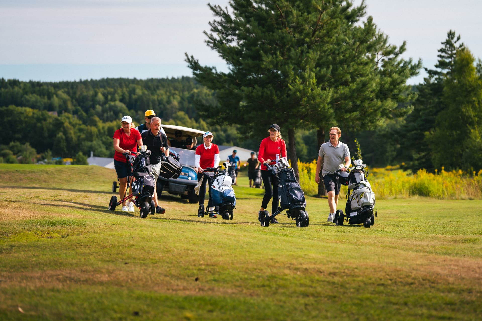 Boll i röda tröjor på väg fram längs fairway